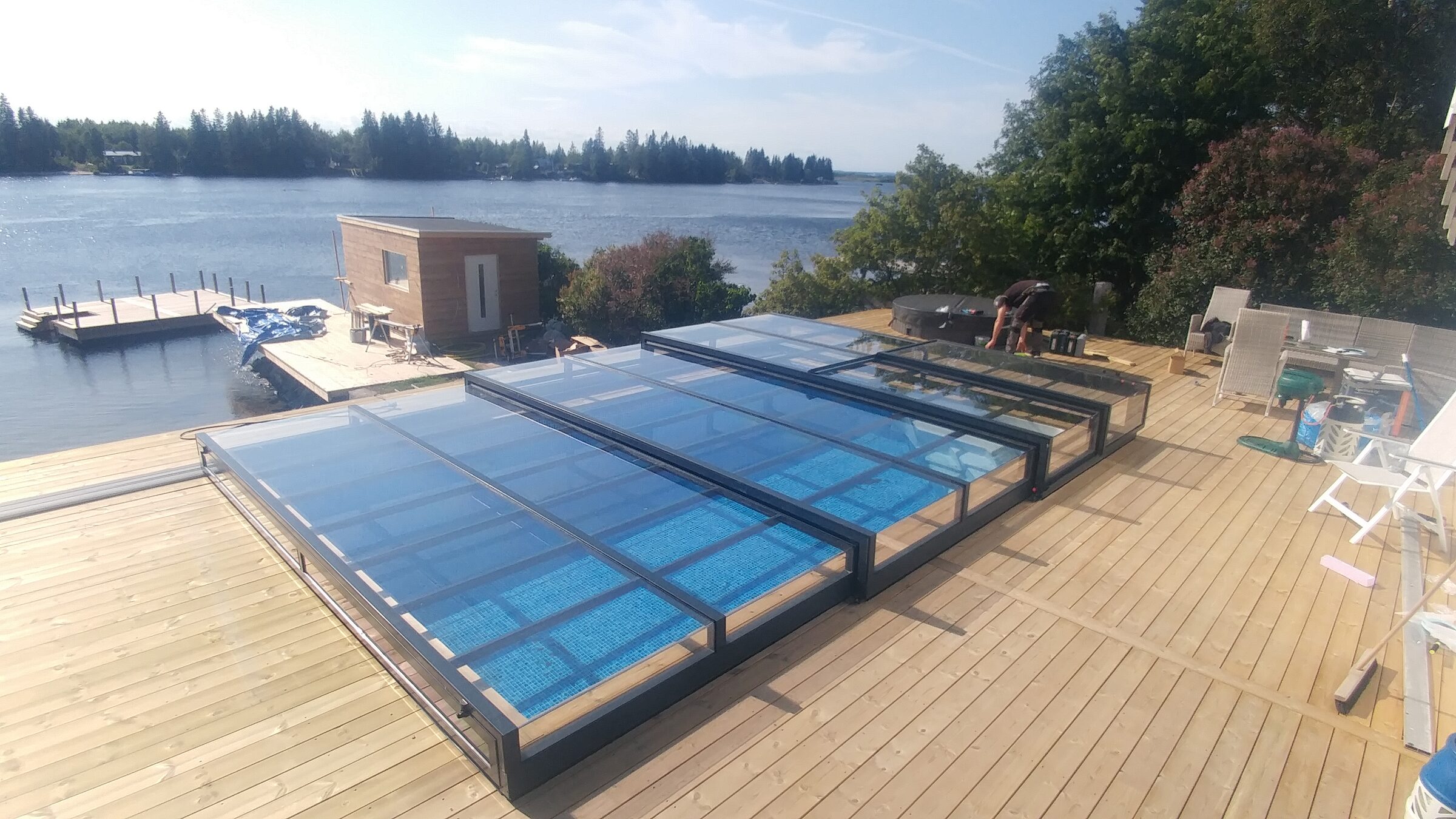 Pool under glasat pooltak med utsikt över älven och en brygga i Husumtrakten