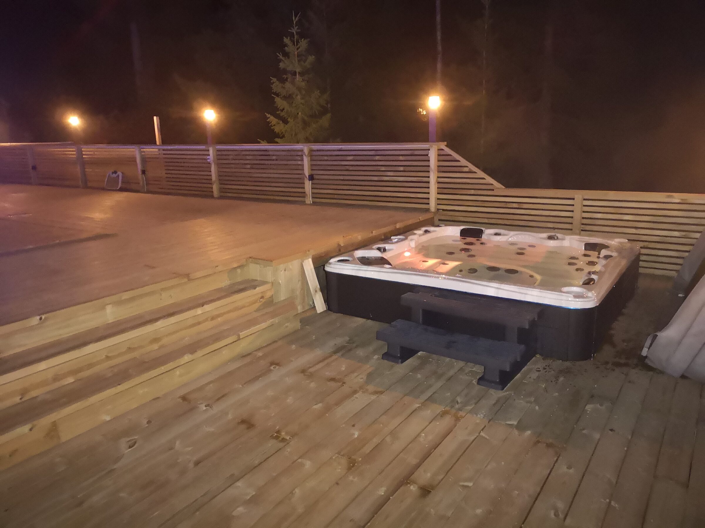Spabad på en altan i kvällsbelysning hos en kund i Örnsköldsvik